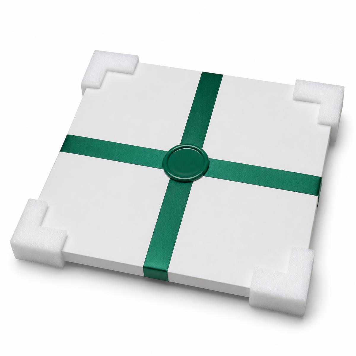 A white packaged artwork with foam corner protectors, emerald ribbon and wax seal